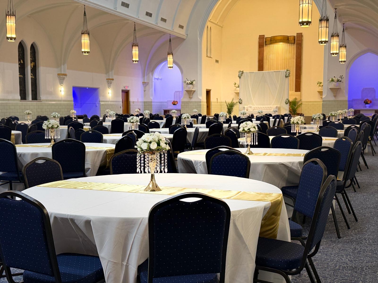 Round tables with white linens, navy chairs and crystal centerpieces