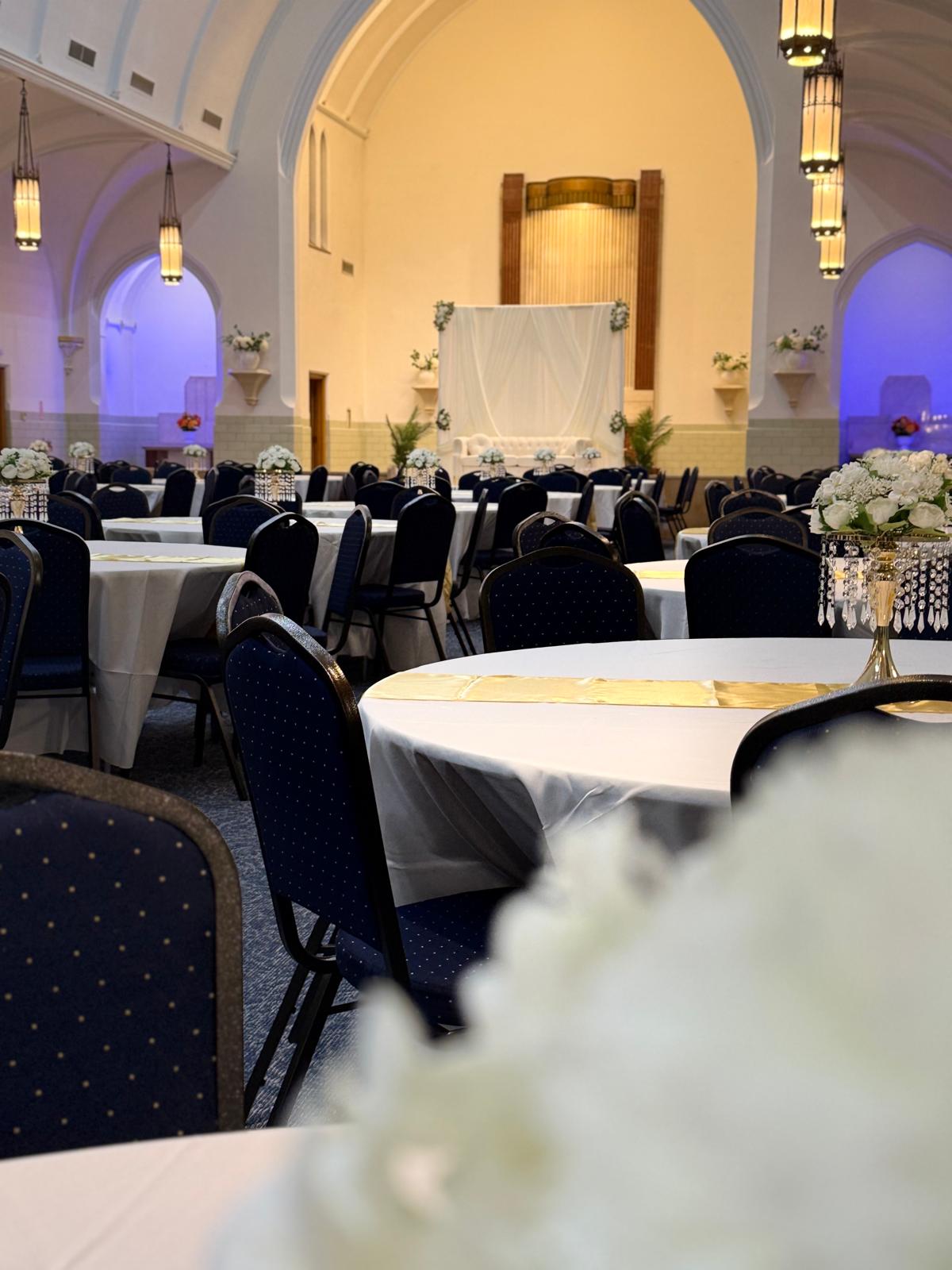 Close view of a set table with gold runner and floral centerpiece